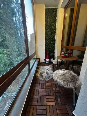 a balcony with a large window and a table and chairs at Winter Lotos Apartment Pamporovo in Pamporovo