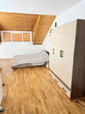 a bedroom with a bed and a wooden floor at Cozy two room maisonette apartment in Samokov