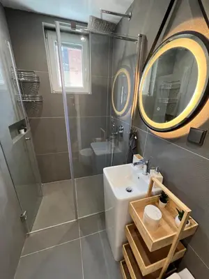 a bathroom with a shower and a sink and a mirror at Celestial Stylish Central 2BDR w WiFi and Work Space in Sofia