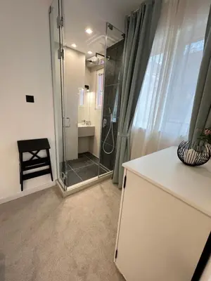 a bathroom with a shower with a glass door at Celestial Stylish Central 2BDR w WiFi and Work Space in Sofia