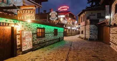 an empty street at night with neon lights at Best Central Lux Studio in Bansko