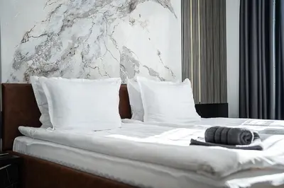 a bed with white sheets and pillows on it at Best Central Lux Studio in Bansko