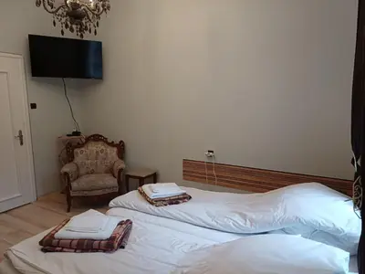 two beds in a room with a tv and a chair at Ktt house in Plovdiv