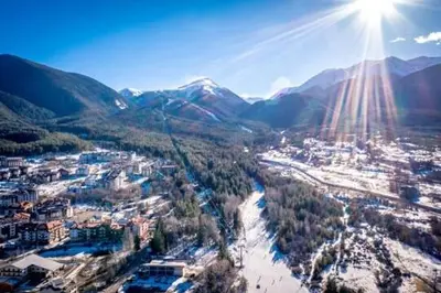 a view of a city with the sun in the sky at Best Central LUX Studio in Bansko