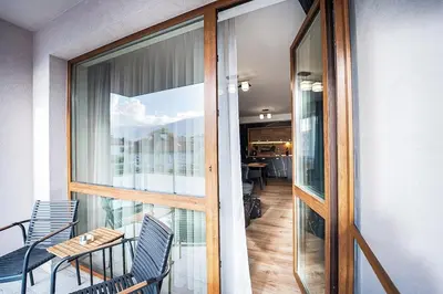 a balcony with chairs and a table and a glass door at Best Central LUX Studio in Bansko