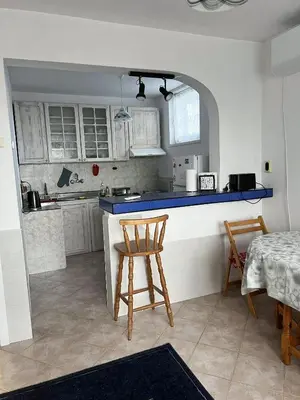 a kitchen with a counter and a table and chairs at Angels Loft opposite The Mall in Sofia