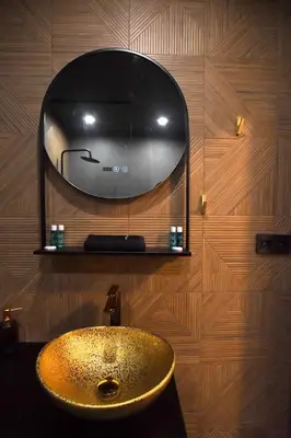 a bathroom with a sink and a mirror on a wooden wall at Contemporary Homes with Balcony in Sofia