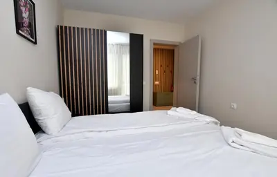 a white bed in a bedroom with a mirror at Contemporary Homes with Balcony in Sofia