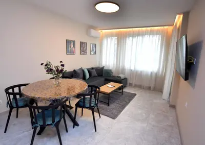 a living room with a table and a couch at Contemporary Homes with Balcony in Sofia