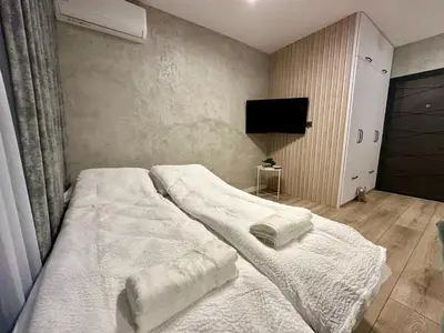 a bedroom with two beds with white sheets and a tv at Casa Nova with Free Garage Parking in Plovdiv