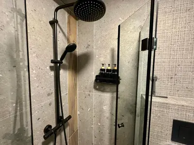 a shower with a glass door with bottles in it at Casa Nova with Free Garage Parking in Plovdiv
