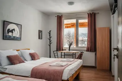 a bedroom with a bed and a table and a window at Guest house ''Viktoria'' in Simitli