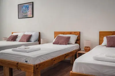 two twin beds in a room with two tables at Guest house ''Viktoria'' in Simitli