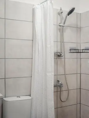 a bathroom with a shower curtain and a toilet at Guest house ''Viktoria'' in Simitli
