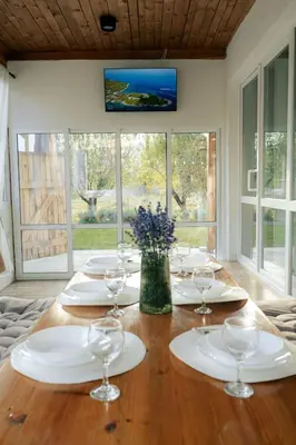 a wooden table with plates and wine glasses on it at Guest house ''Viktoria'' in Simitli