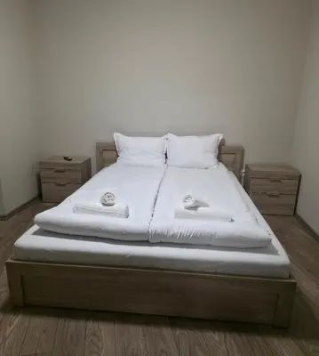a bed with white sheets and pillows on it at Апартаменти Шадравана in Samokov