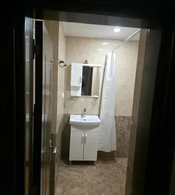 a bathroom with a white sink and a shower at Апартаменти Шадравана in Samokov