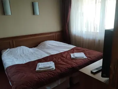 a room with a bed with two towels on it at хотел София in Bansko