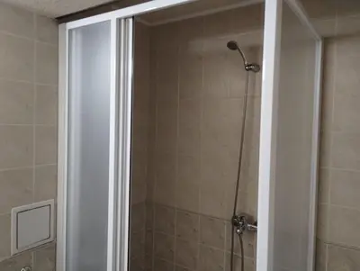 a shower with a glass door in a bathroom at хотел София in Bansko