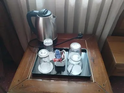 a table with a coffee pot and glasses on it at хотел София in Bansko
