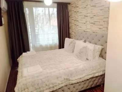 a bedroom with a white bed with a brick wall at Luxury studio Perun Lodge in Bansko
