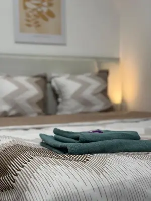 two green towels sitting on top of a bed at Botev MiniHub Hub 2 Modern Studio at Botev 88 in Sofia