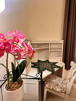 a room with pink flowers and a table and chairs at Vinny's Place in Sofia