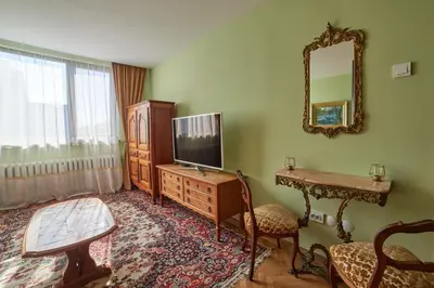a living room with a tv and a table and a mirror at Fabulous Retro Apartment in the Heart of Sofia in Sofia