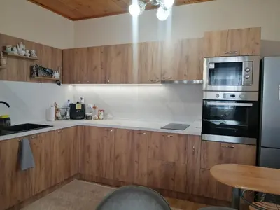 a kitchen with wooden cabinets and a microwave oven at Уют in Haskovo