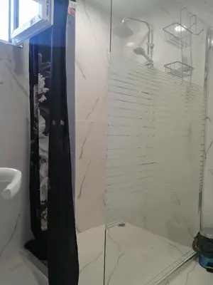 a shower with a glass door in a bathroom at Уют in Haskovo