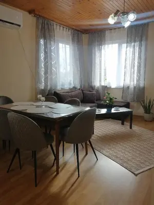 a living room with a table and chairs and a couch at Уют in Haskovo