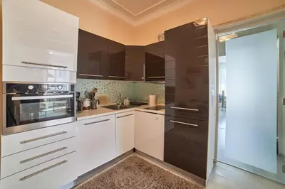 a kitchen with white cabinets and black appliances at Heart of Sofia 2 Bdr Elevator Balcony Relax in Sofia