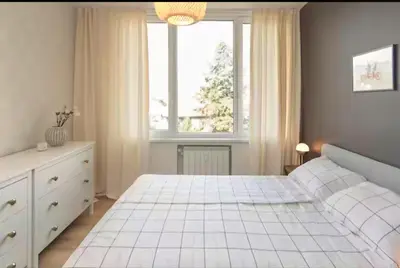 a bedroom with a white bed and a window at Mattea's 2-bedroom apartment in Sofia