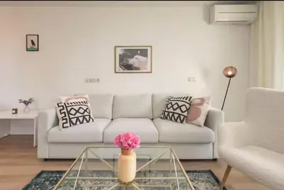a living room with a white couch and a glass table at Mattea's 2-bedroom apartment in Sofia
