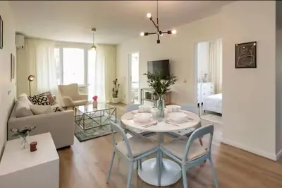 a living room with a table and chairs at Mattea's 2-bedroom apartment in Sofia