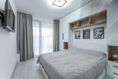 a white bedroom with a bed and a window at Bright and Cozy Apartment at a quiet Location in Sofia