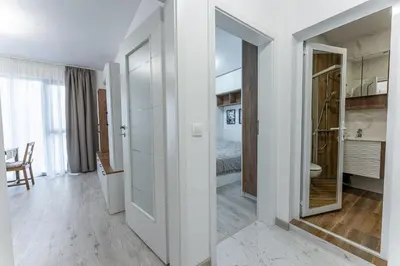a white room with a bedroom and a bed at Bright and Cozy Apartment at a quiet Location in Sofia