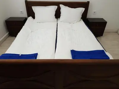 a bed with white sheets and blue pillows at Moder and Old Top in Sofia