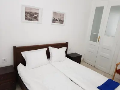a bed with white sheets and pillows in a bedroom at Moder and Old Top in Sofia