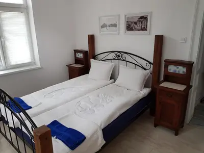 a bedroom with a bed with white sheets and blue and white pillows at Moder and Old Top in Sofia