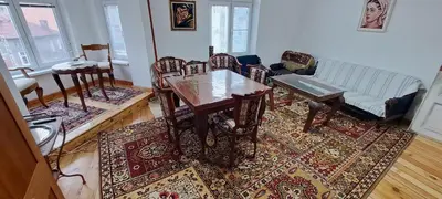 a living room with a table and chairs on a rug at Moder and Old Top in Sofia