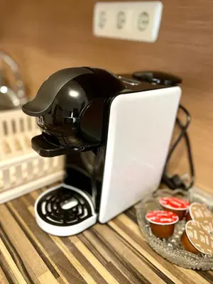 a coffee maker sitting on a table next to cupcakes at Steps from Gondola Private Underground Parking by SI Stay in Bansko