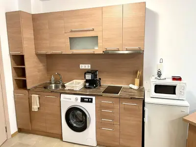 a kitchen with a washing machine and a microwave at Steps from Gondola Private Underground Parking by SI Stay in Bansko