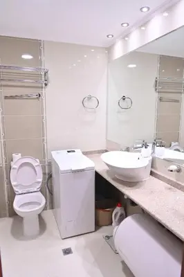 a white bathroom with a toilet and a sink at Riverside 1BR in Downtown Near Ski Lift by Flat Mаnаger in Bansko