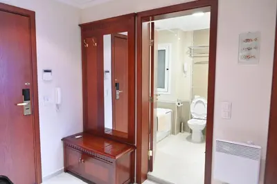 a bathroom with a wooden cabinet and a toilet at Riverside 1BR in Downtown Near Ski Lift by Flat Mаnаger in Bansko