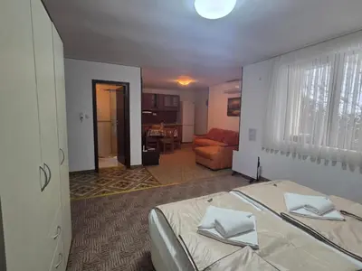 a bedroom with a bed and a living room at Апартамент Маунтин лодж in Pamporovo