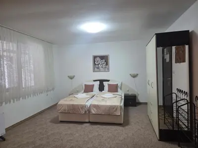 a bedroom with a bed in a white room at Апартамент Маунтин лодж in Pamporovo