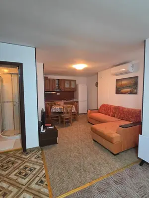a living room with a couch and a table at Апартамент Маунтин лодж in Pamporovo