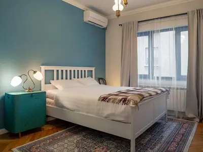 a bedroom with a white bed and a blue wall at Central Sofia 2BR Apt City Center Historic in Sofia
