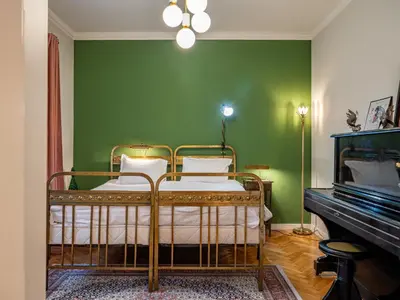 a bed in a green room with a piano at Central Sofia 2BR Apt City Center Historic in Sofia
